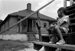 Photograph: Negro boy sitting on steps outside big house